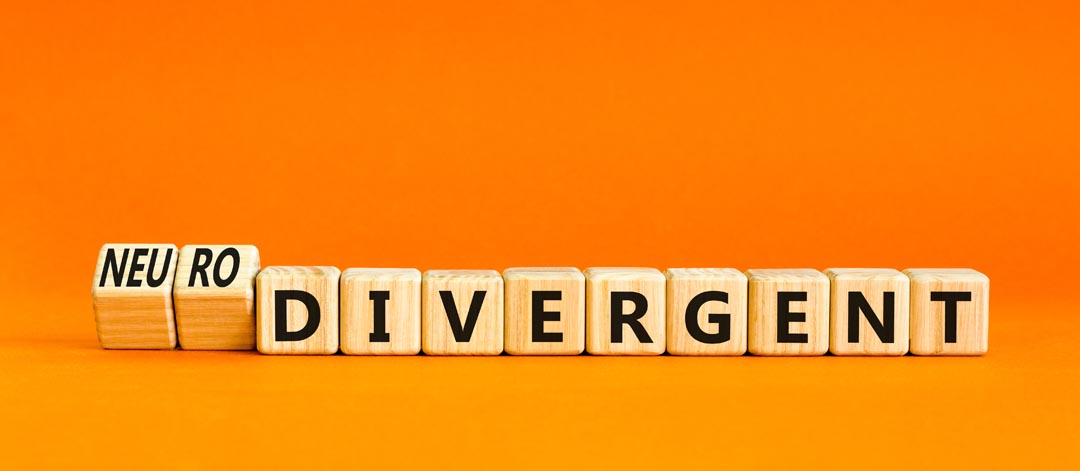 Neurodivergent word on wooden blocks. Beautiful orange table orange background.