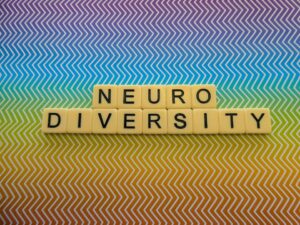 Bright rainbow zig zag pattern background sign with the word "NEURODIVERSITY"