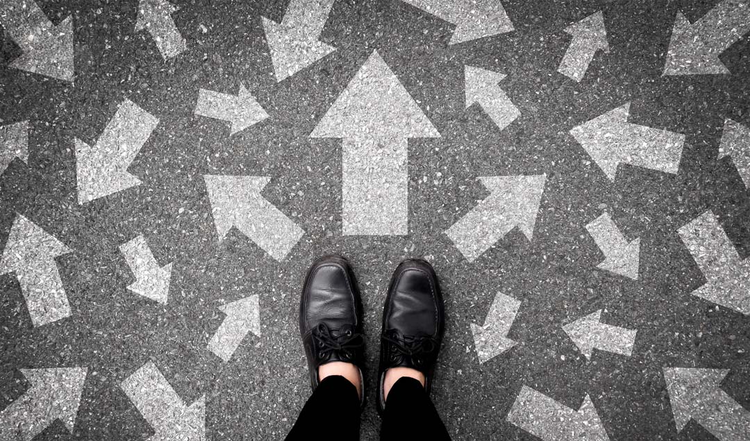 Selfie of feet and arrows on road. Top view of person's shoes.