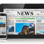 "News" written on the digital version of a newspaper showing on a tablet and mobile phone.