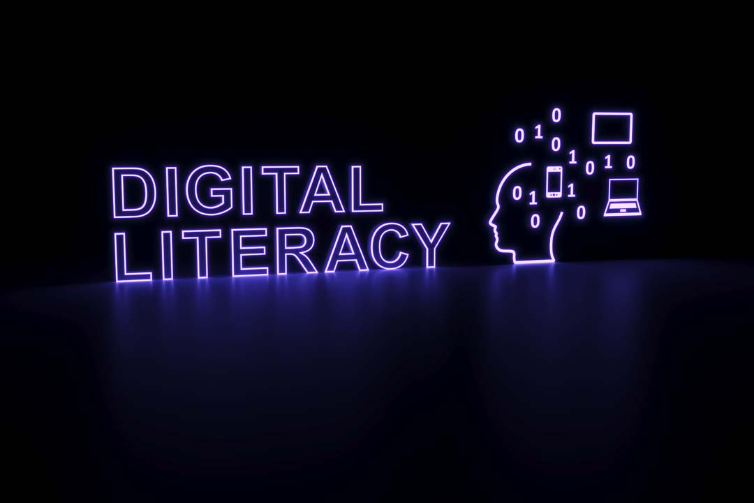 Black background, with purple neon writing of "digital literacy" and icons of a head to symbolise thinking