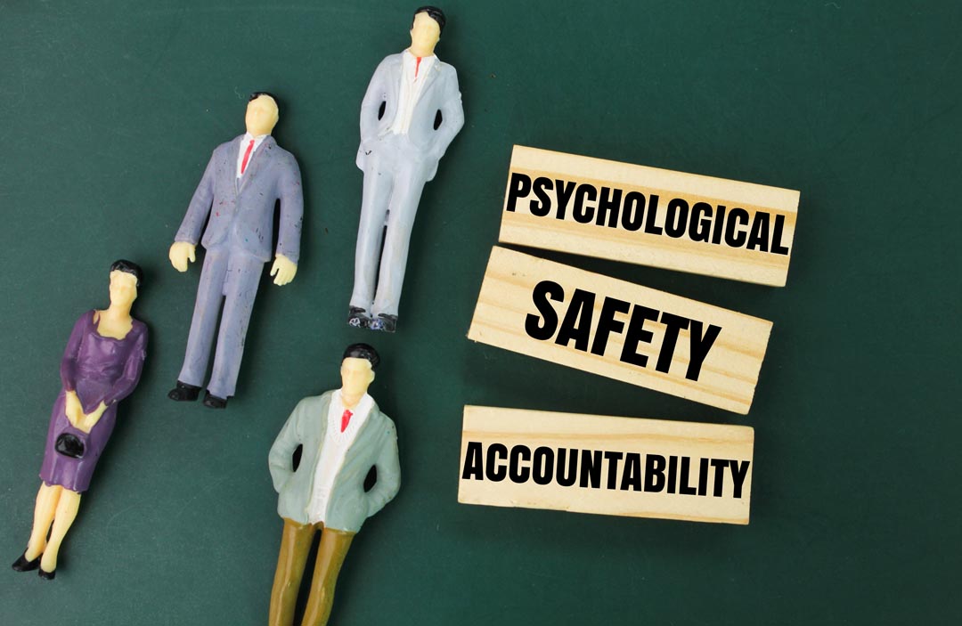 Miniature and wooden people with the word psychological safety and accountability