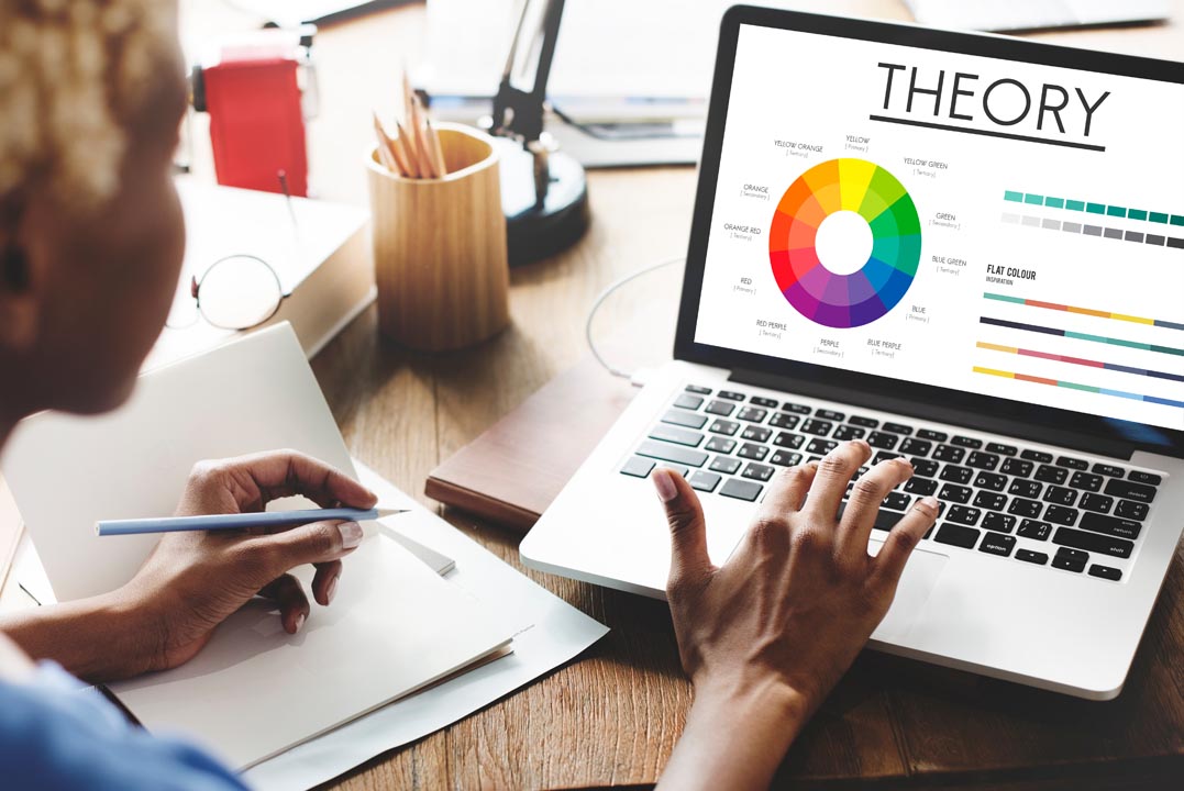 Woman of colour using a laptop with the colour wheel on it.