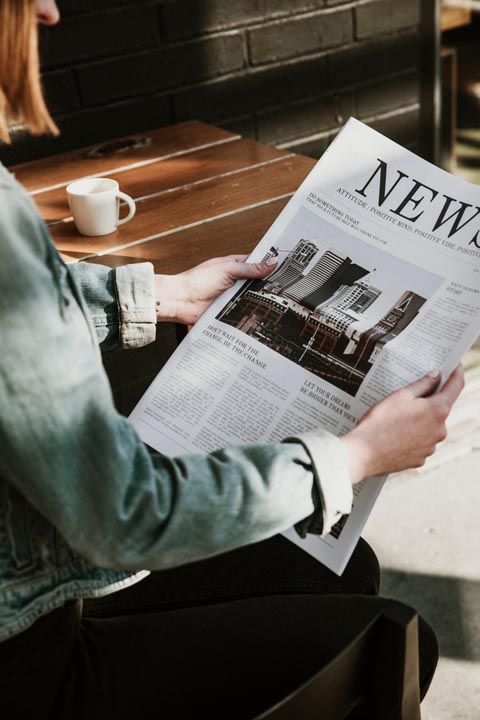 Woman reading newspaper.