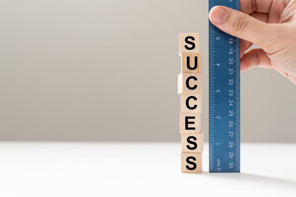 Measure success word using blue ruler, representing a review, evaluation or assessment of an employee