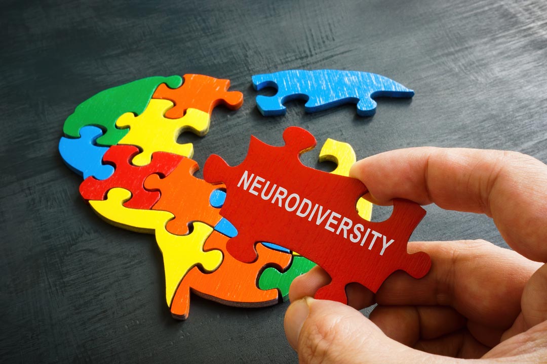 Neurodiversity concept. Brain from puzzle and a hand holds a piece with an inscription of the word neurodiversity.