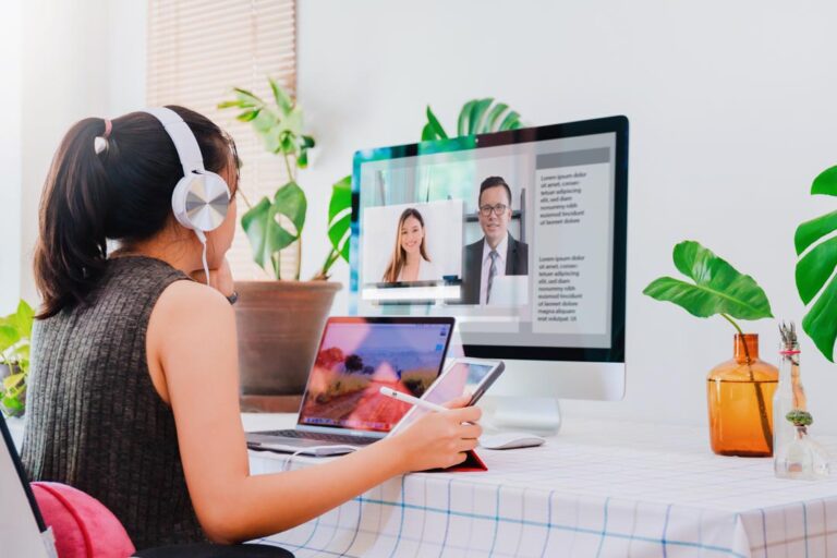 Asian business woman work from home with laptop, tablet and computer on table with meeting online and video conferencing.