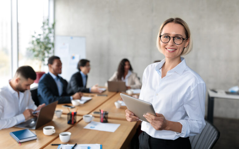 Successful Businesswoman Holding Digital Tablet Standing In Modern Office