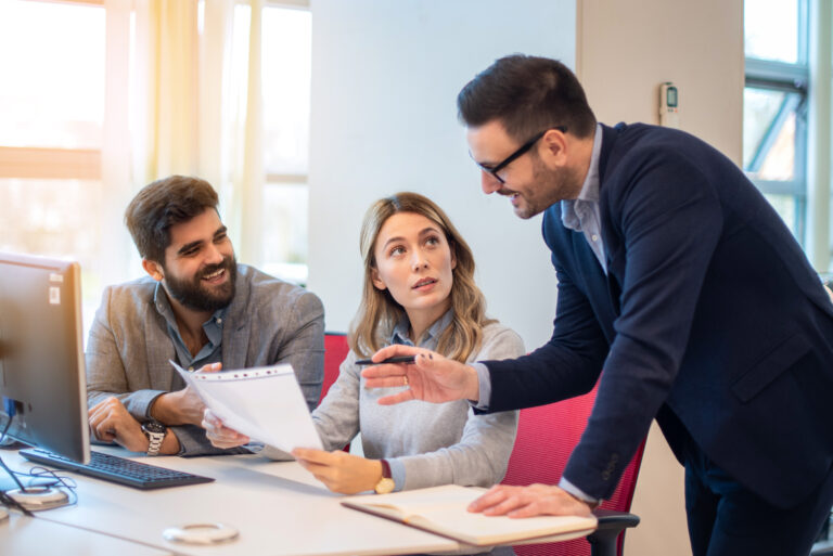 Business people discussing an agenda document containing topics, action items, and activities of their organization during the meeting.