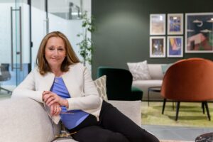 Dr Lynda Shaw by photographer Pennie Withers - white woman with blond hair relaxing on a chair
