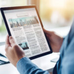 unrecognizable man Reading Digital Newspaper on Tablet in Office - news