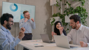 Multi ethnic diverse business team colleagues co-workers corporate partners celebrate victory successful teamwork achievement good result happy businessmen businesswoman in boardroom office win deal