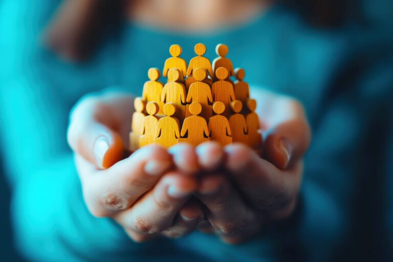 Protecting Our People: Hands carefully cradling a miniature community, symbolizing care, support, and the importance of human connection in a world that needs more empathy.