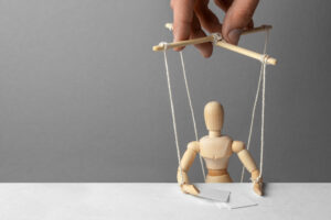 Puppeteer manipulates the doll. The conference is unfair. Fake person at conference or meeting. Fake news