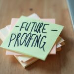 A vibrant stack of sticky notes sits on a wooden desk, with a bold Future Proofing note prominently displayed. This image captures the essence of planning and innovation, inspiring viewers to think