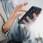 Business woman, hands and typing with phone for research, online browsing or reading news at office. Closeup of female person or employee scrolling on mobile smartphone for chatting, texting or app