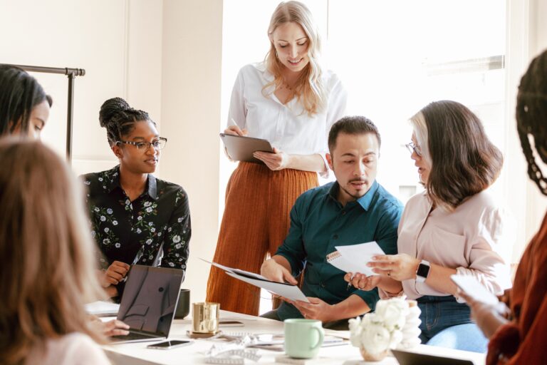 Diverse team in a meeting. A diverse team in a business meeting. The team discusses and brainstorm. The diverse business team collaborates in a bright office. Diverse group of people in meeting room