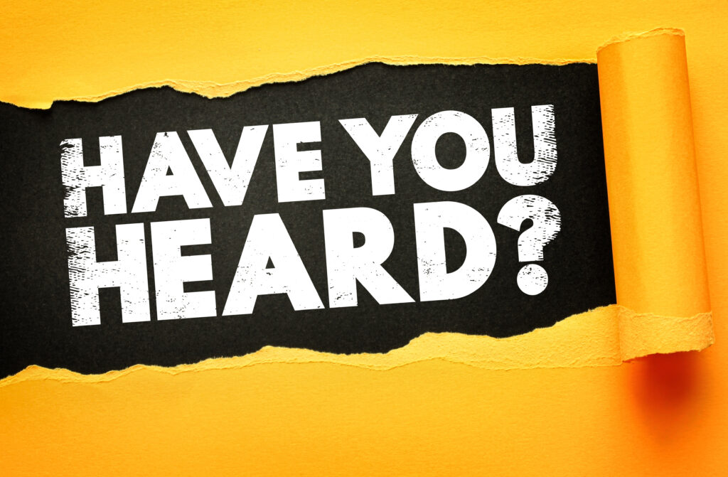 Bold white text "HAVE YOU HEARD?" emerges behind torn yellow paper on a black background, symbolizing breaking news, exciting updates, announcements, curiosity, or viral trends in marketing