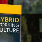 Hybrid Working Culture sign in a busy commuter city center