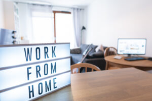 Working from home remote work inspirational social media lightbox message board next to monitor, COVID-19 quarantine closure of all. Apartment background