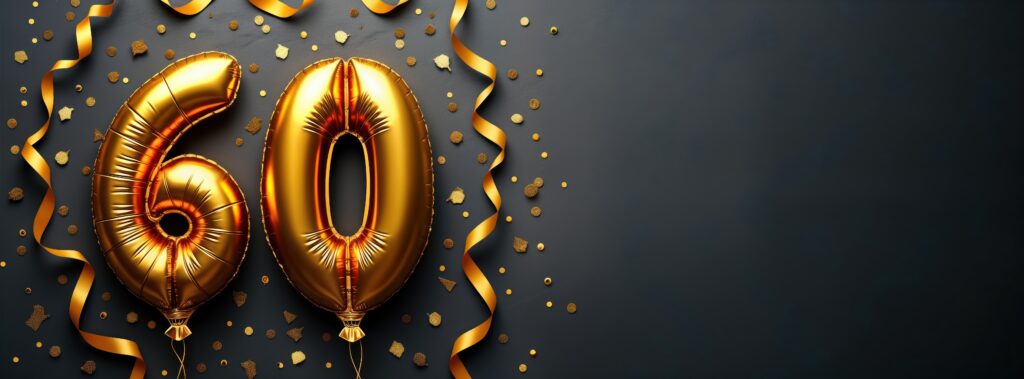 Gold foil balloons shaped as number sixty. Festive celebration decor. Black concrete background with golden confetti, ribbons. Anniversary birthday celebration concept. Top view design. Party