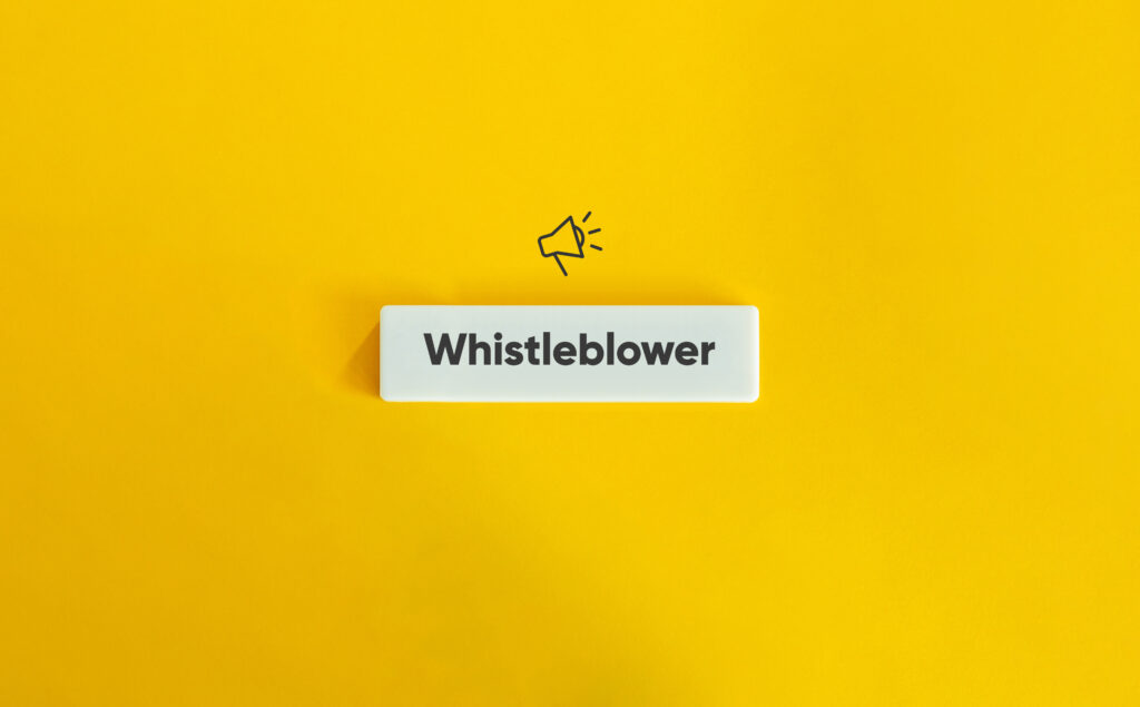 Whistleblower Protection Concept Image. Financial Crime and Fraud. Text on Block Letter Tile and Megaphone Icon on Yellow Background. Minimal Aesthetic.