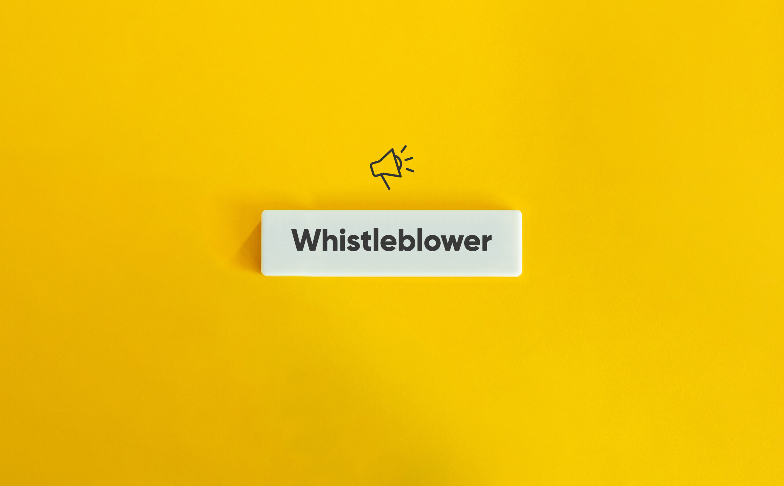 Whistleblower Protection Concept Image. Financial Crime and Fraud. Text on Block Letter Tile and Megaphone Icon on Yellow Background. Minimal Aesthetic.