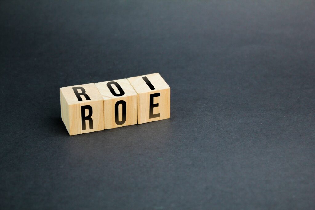 wooden cube with letters ROI and ROE. Return on Equity (ROE) vs. Return on Investment (ROI)