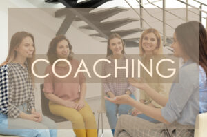 Adult learning. Word COACHING and cheerful ladies at meeting on background