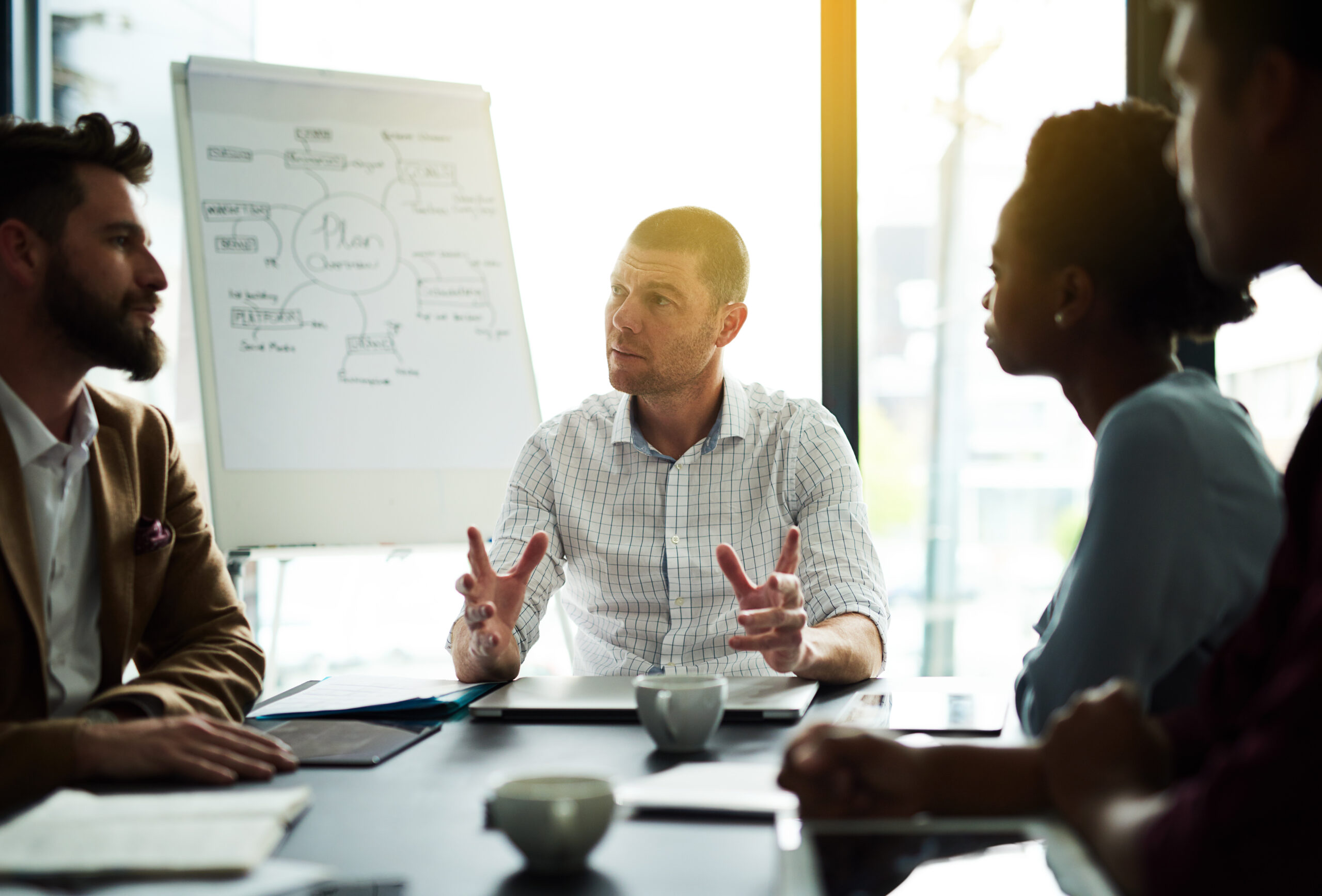 Businessman, discussion and meeting with team for brainstorming, presentation or planning at office. Man talking or explaining work, tasks or agenda to group of employees for project at workplace