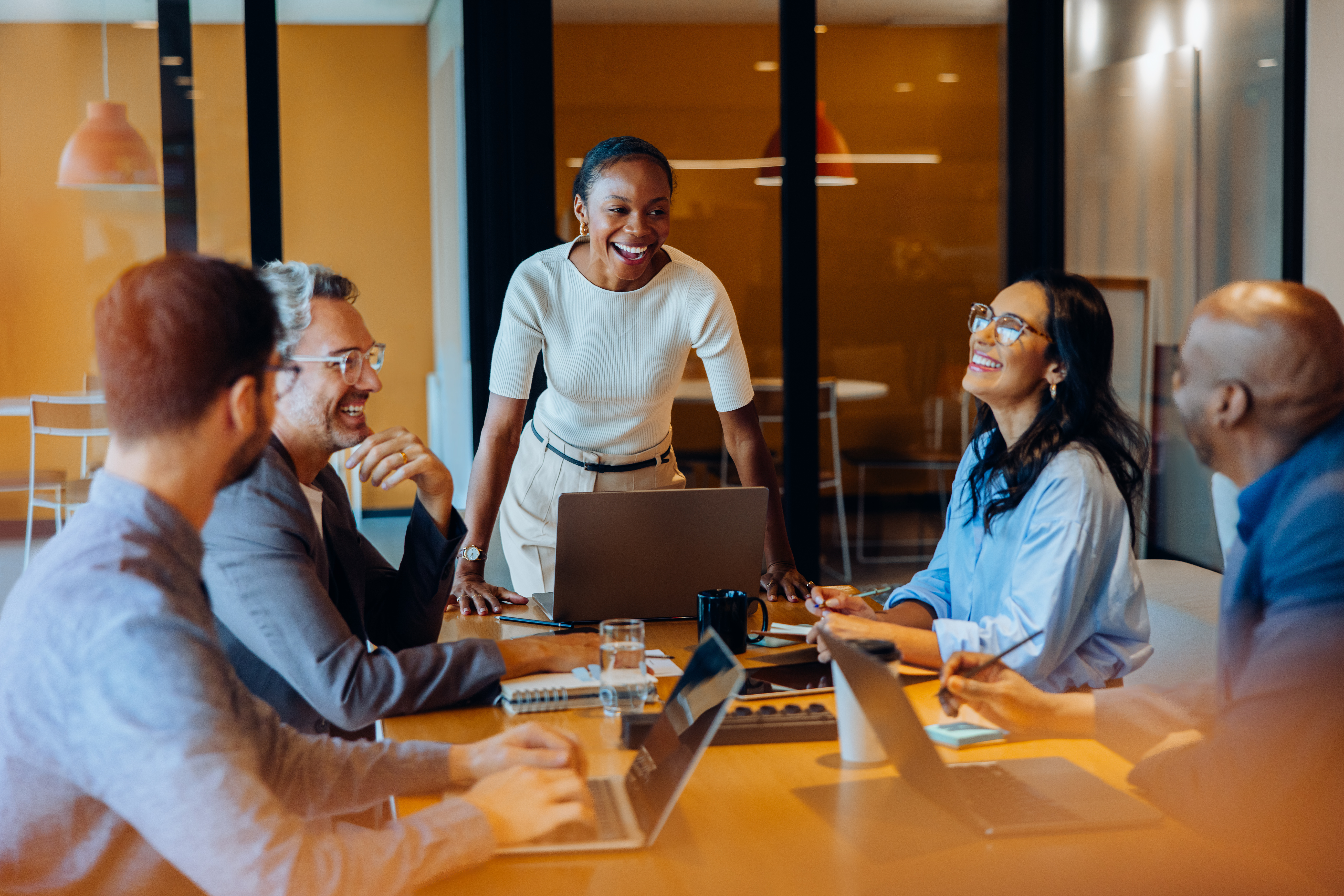 Diverse team engaged in discussion around a desk in a corporate office
