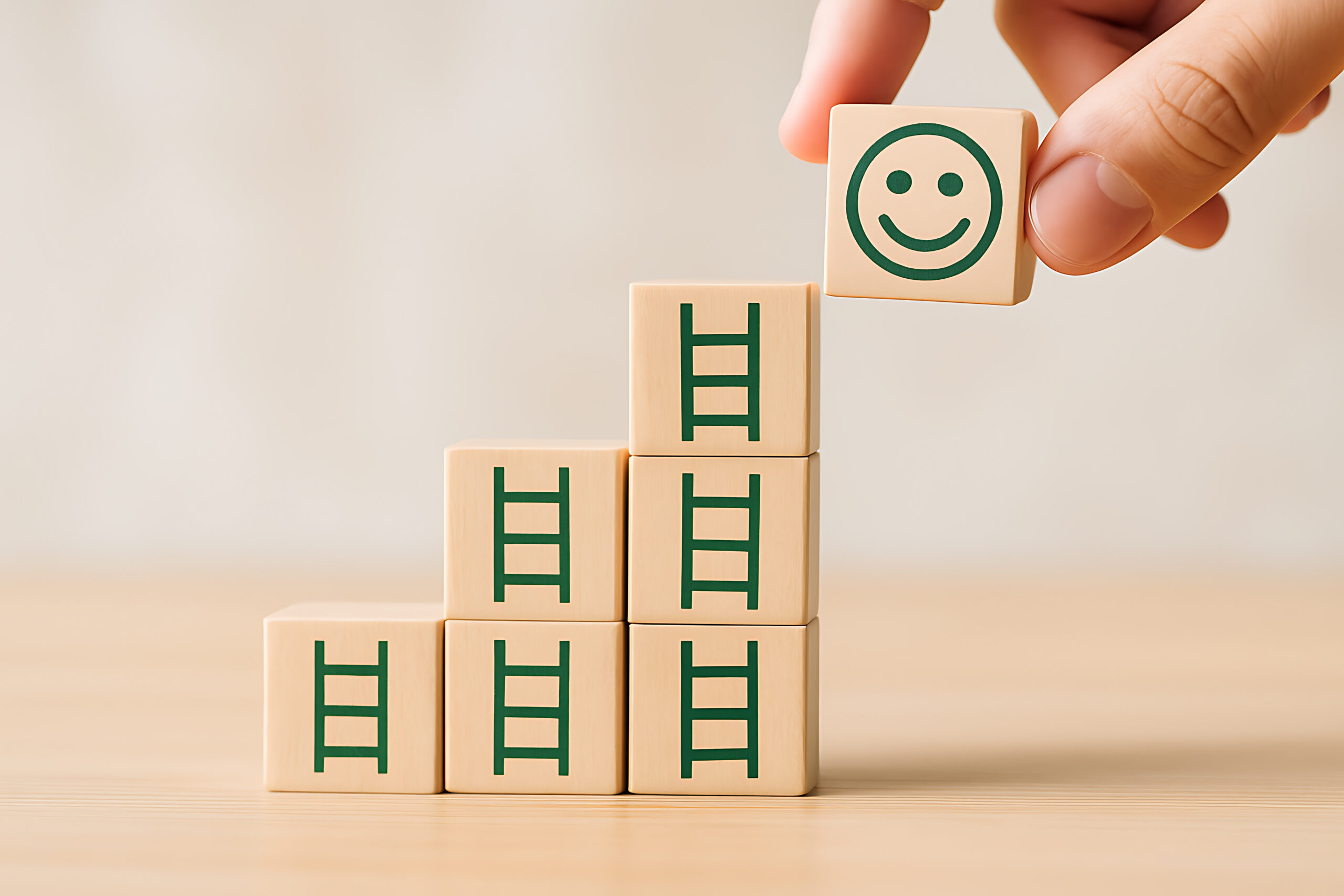 Career progress and personal happiness concept with wooden blocks and smile icon