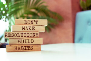 Wooden blocks with words 'Don't Make Resolutions Build Habits'.