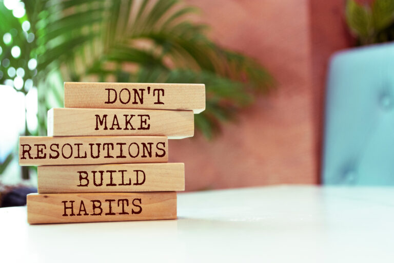 Wooden blocks with words 'Don't Make Resolutions Build Habits'.