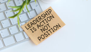 A keyboard with a piece of paper that says Leadership is not position