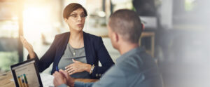 Office, business people and woman with discussion for laptop screen, financial strategy and report. Teamwork, employees and manager in meeting for accounting firm, profit growth and planning by flare