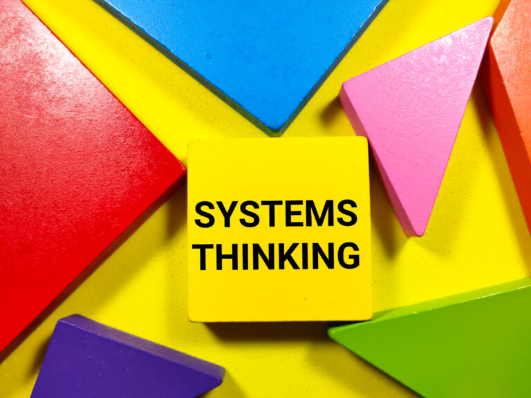Business concept.Text SYSTEMS THINKING writing on colored tangram on a yellow background.