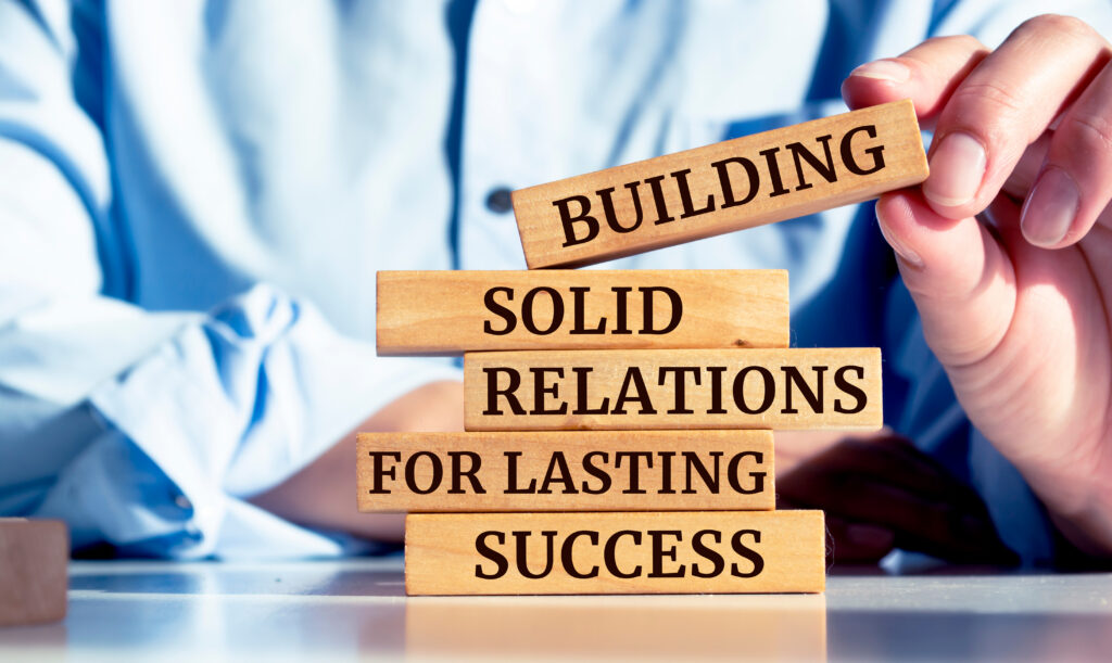 Close up on businessman holding a wooden block with Building Solid Relations For Lasting Success message
