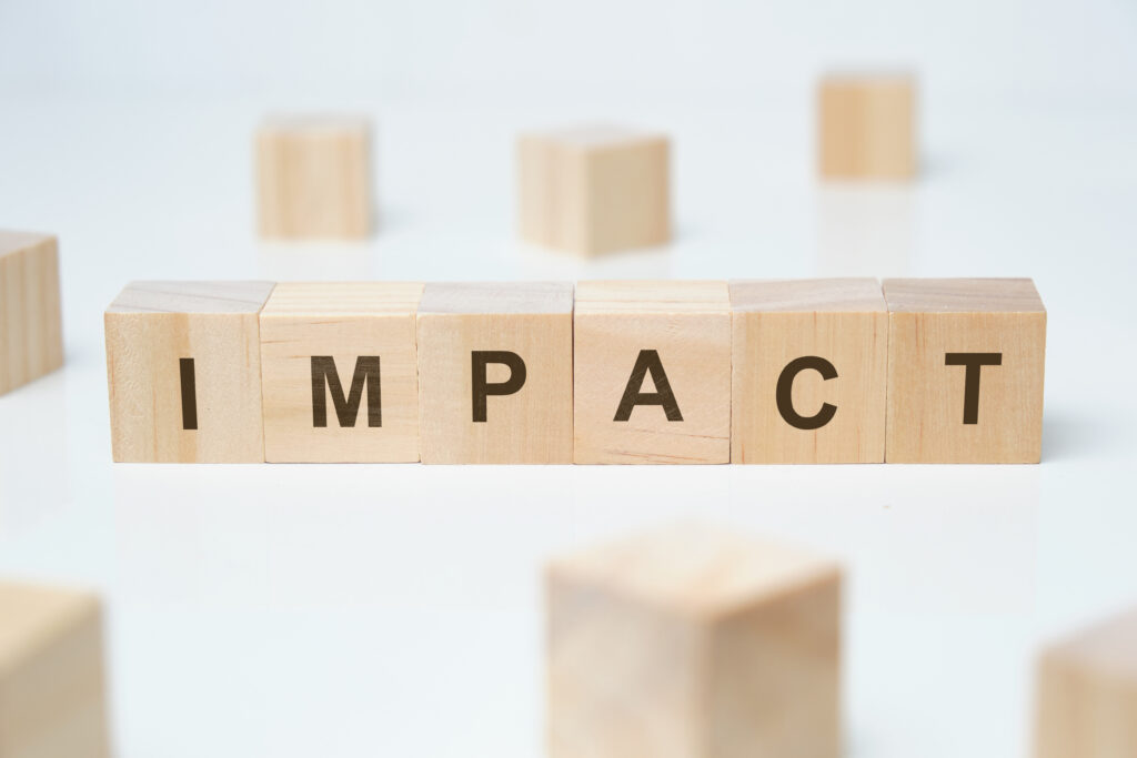 Modern business buzzword - impact. Word on wooden blocks on a white background.