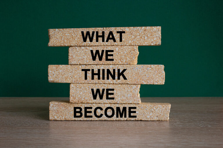 We become or think symbol. Concept word What we think We become on brick blocks. Beautiful wooden table, green background. Business we become or think concept. Copy space.