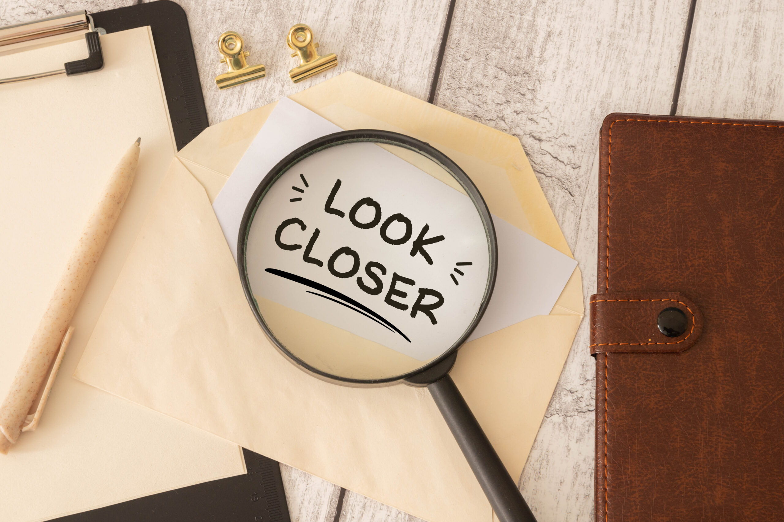 Look Closer Concept with Magnifying Glass Over Envelope on Office Desk