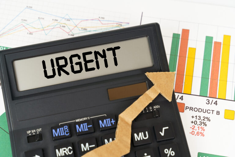 On the business charts there is a calculator on the screen with the inscription - Urgent