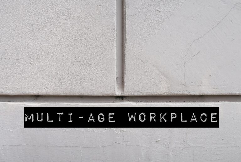 White office wall with words MULTI-AGE WORKPLACE, refers to multi-generational workforce and age diversity in environment in office or organization
