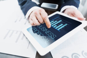 Close-up of modern businessman presenting business proposal at meeting at office from tablet computer